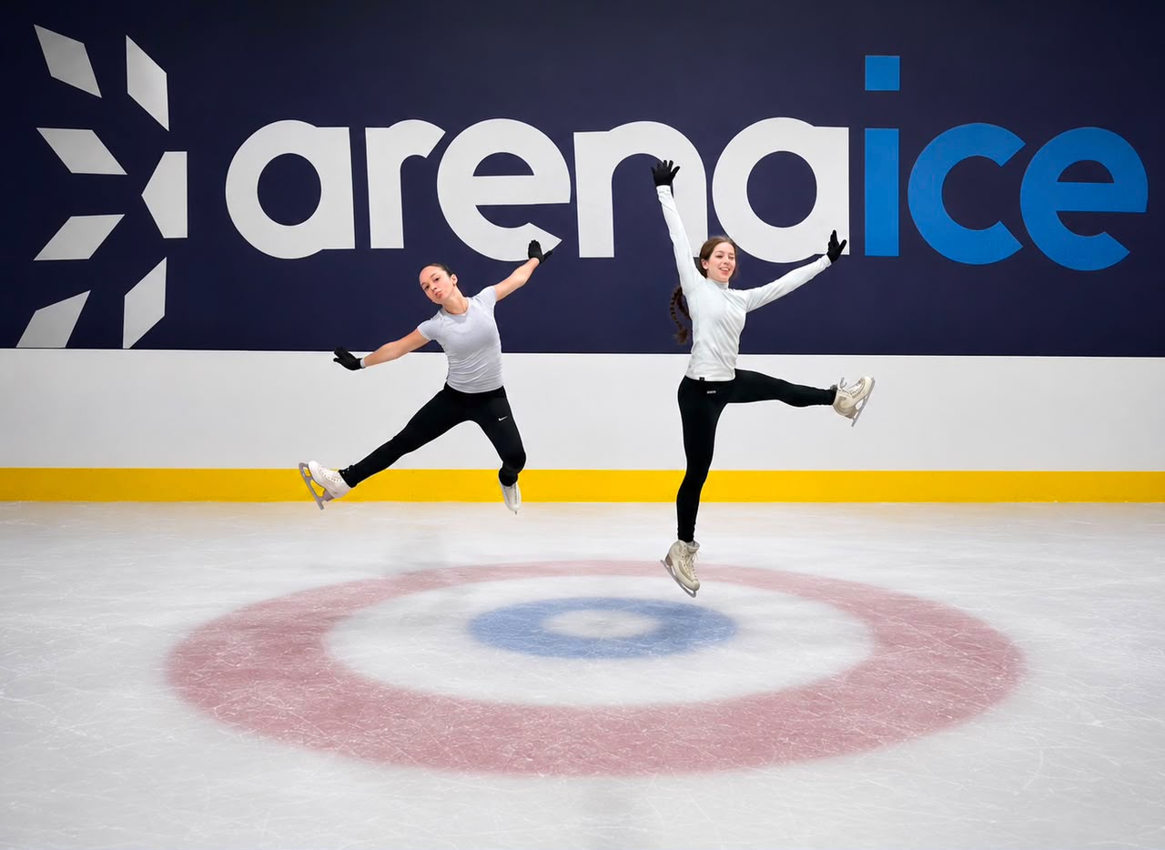 Patinadoras saltando em frente ao painel da Arena Ice